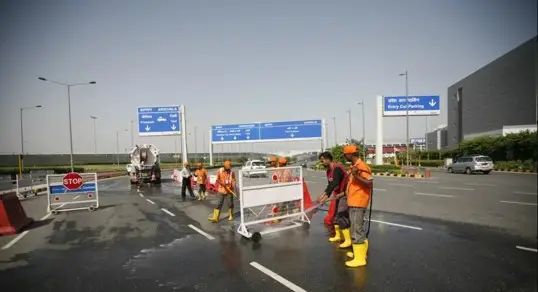 Sanitation workers cleaning roads near Delhi airport