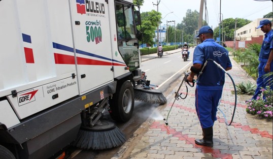 Mechanized road sweeping with cleaning staff
